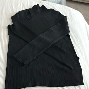 Rachel Rachel Roy black turtleneck with shouldered slit on the right side.